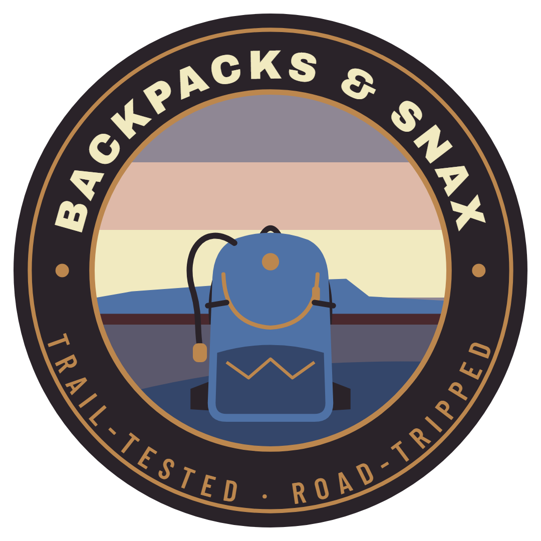 Backpacks and Snax trailhead badge: a blue backpack in front of a sunset, ringed by the words Trail-tested, Road-tripped